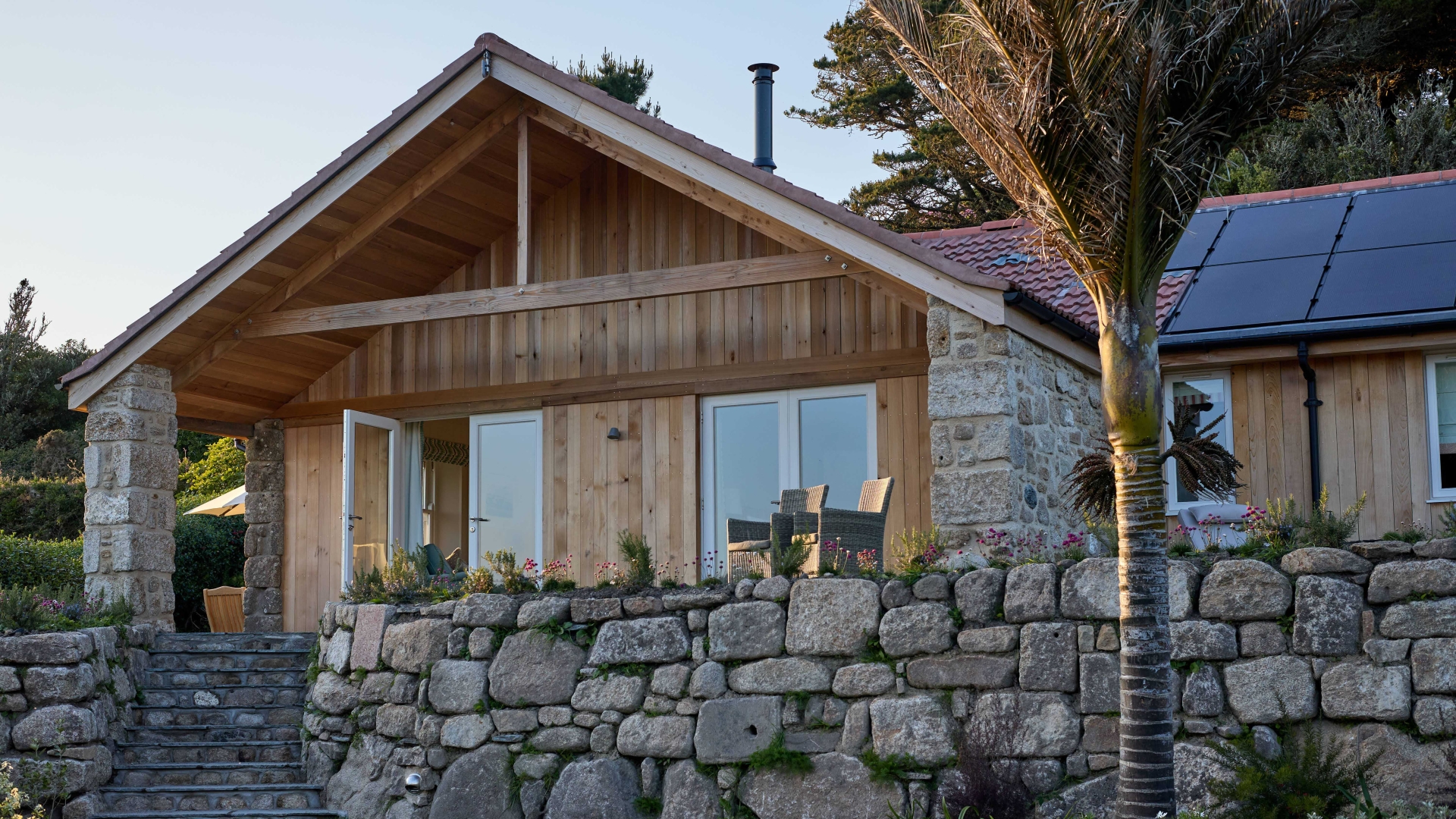 Timber-clad garden building framed by evening light